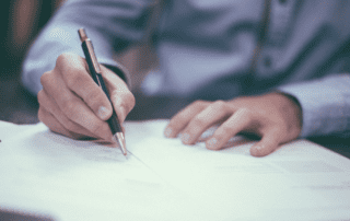 Older man signing a paper