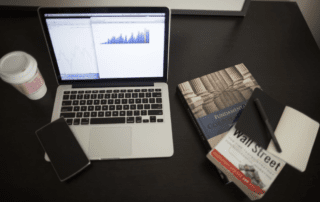 Finance charts on a computer with finance books.